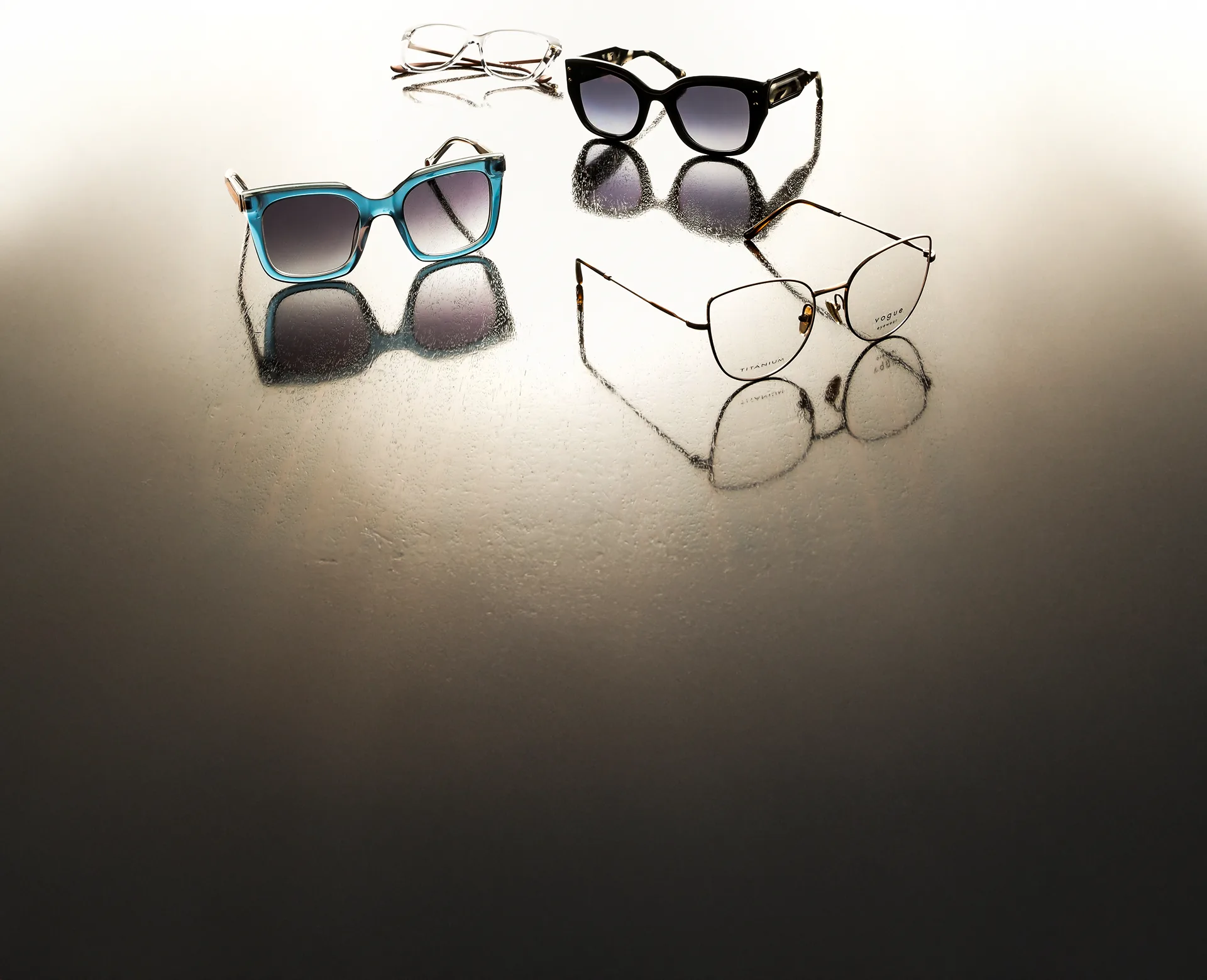 Gafas de sol y armazones sobre una superficie reflectante